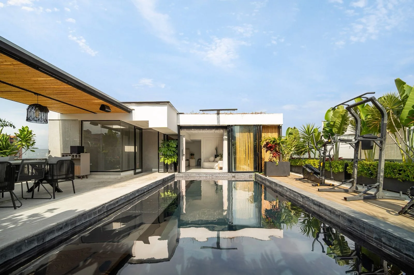 Piscina central de la terraza con zona de ejercicio y cielo azul