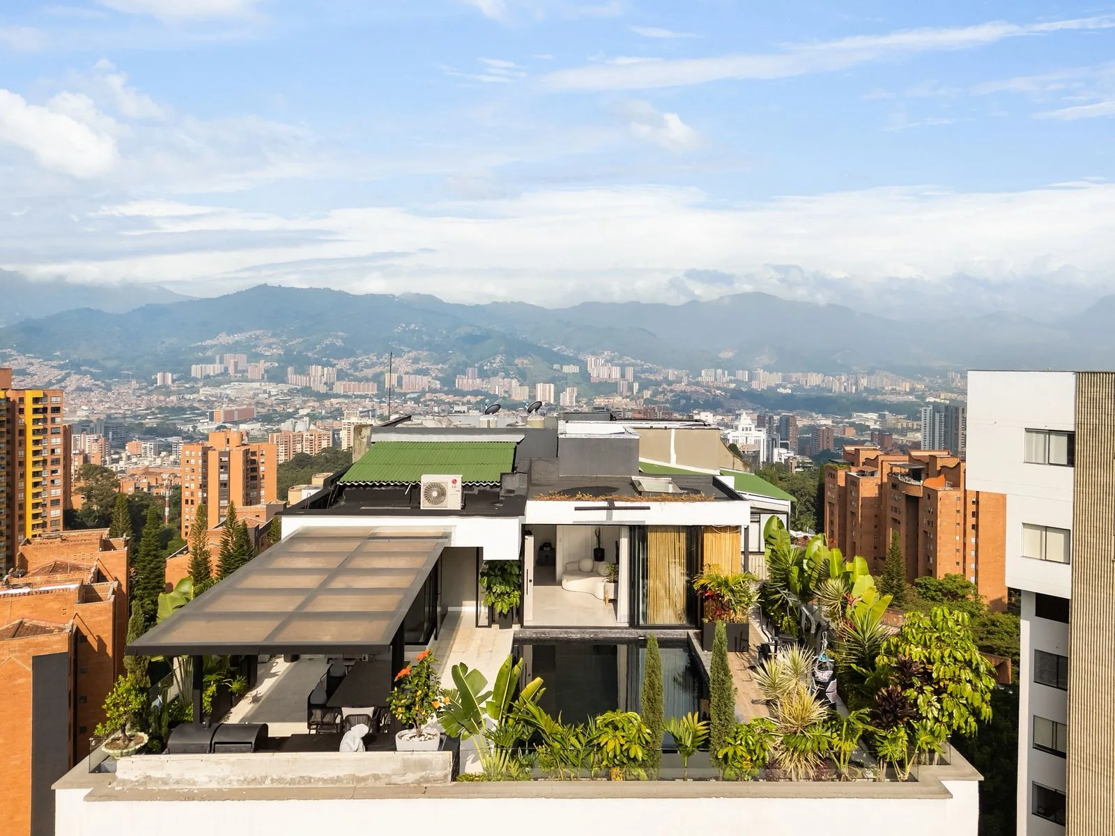 Vista aérea de la terraza ajardinada y el perfil urbano de Medellín