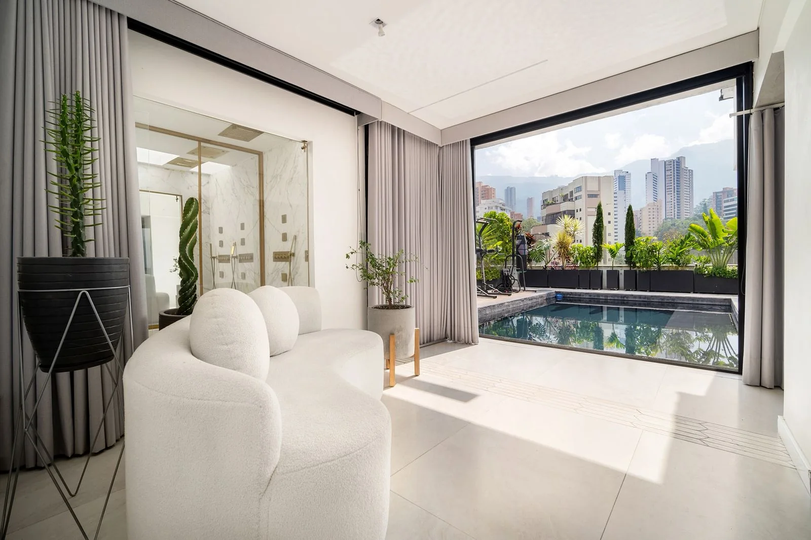 Estar privado de la suite con ventanales abiertos hacia la piscina