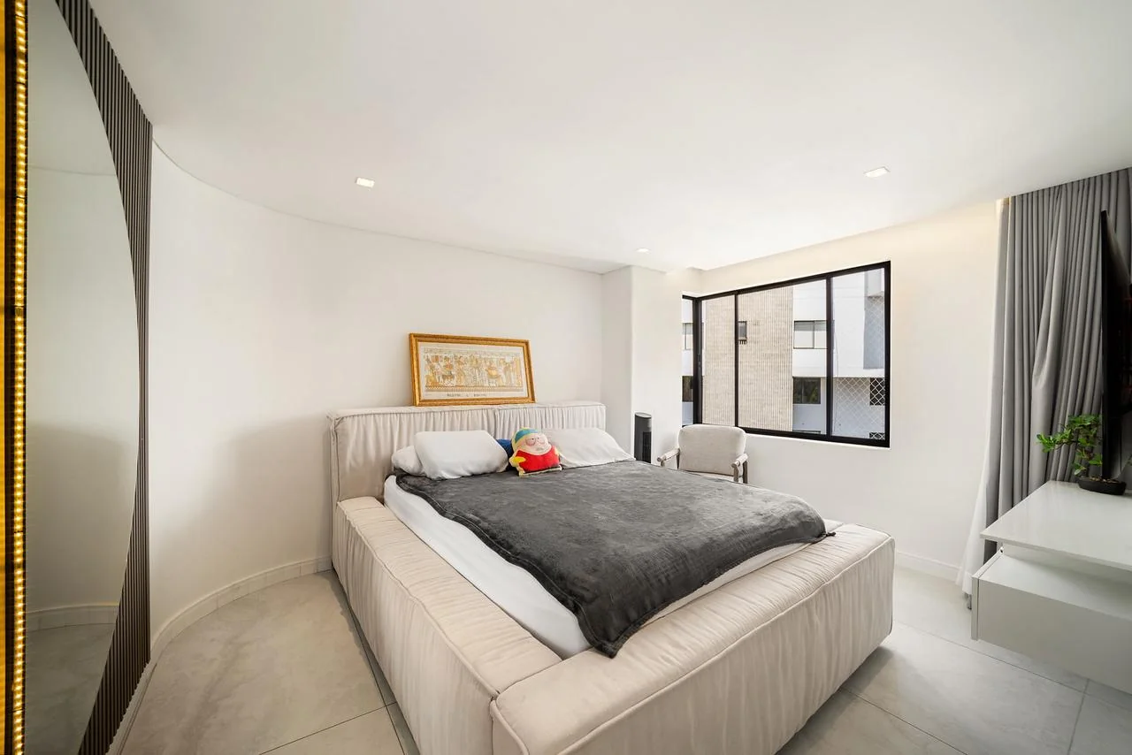 Habitación de huéspedes en tonos claros con cama doble y ventanal